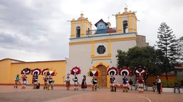 Danzantes de la pluma con penachos frente al templo de Santo Tomás Apóstol, en Santo Tomás Jalieza.